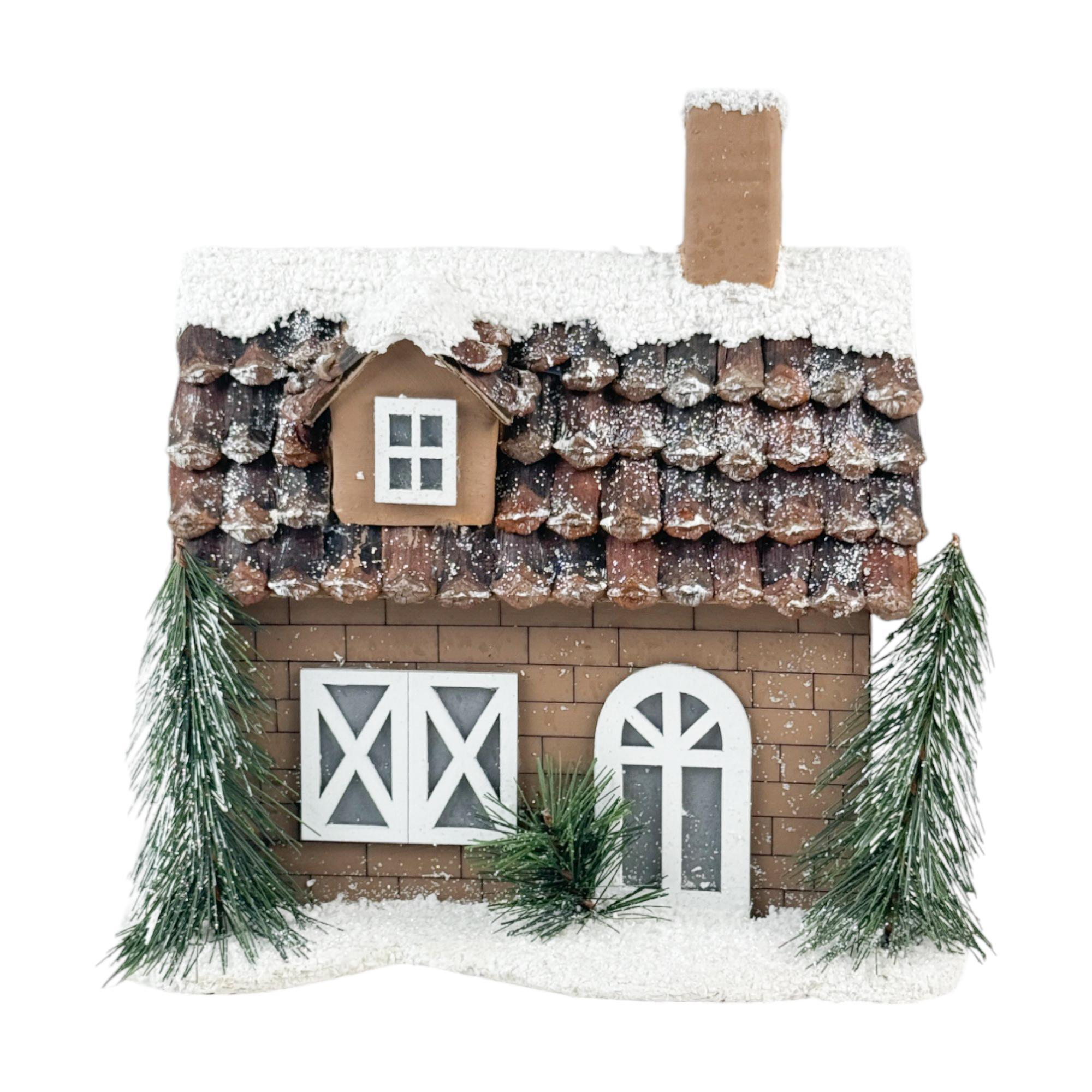 Casita marrón con nieve y pinos